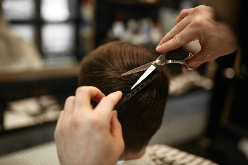 Photo by Hair Spies a person cutting another persons hair with a pair of scissors